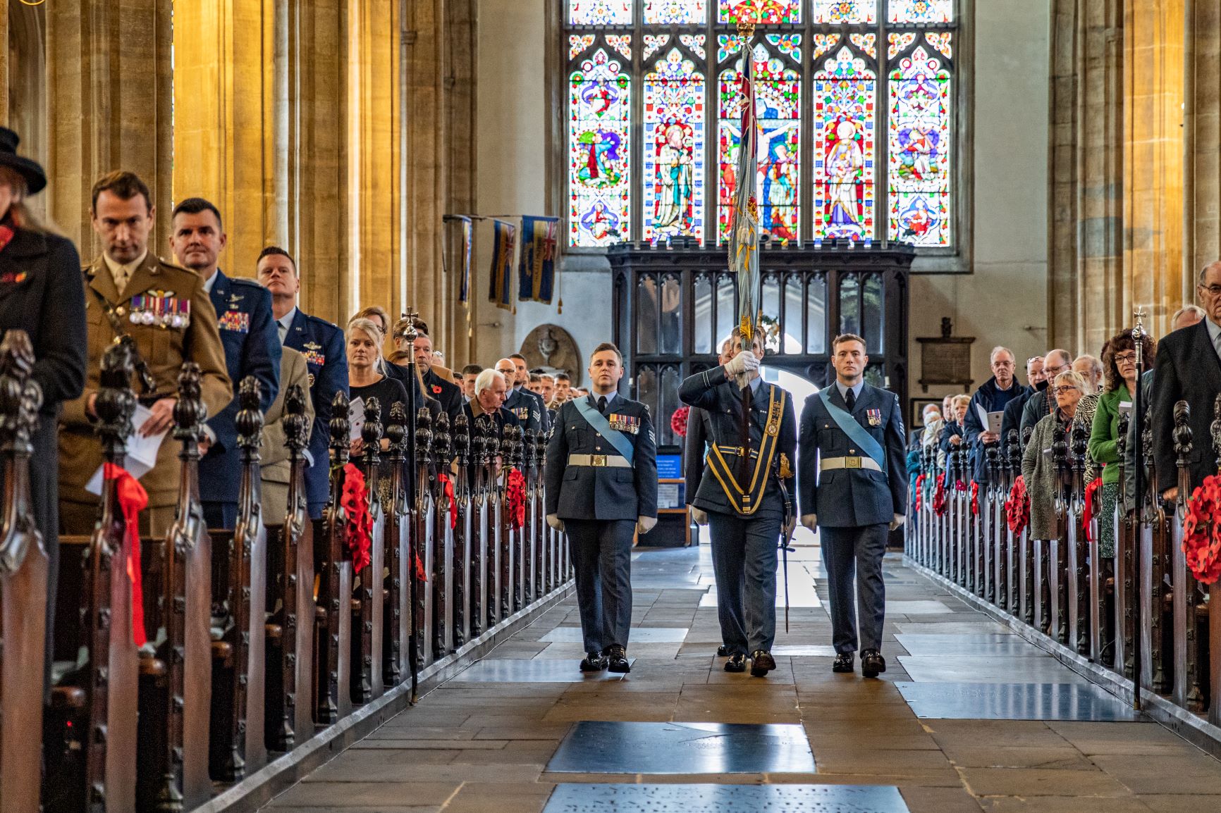 Image shows RAF aviators carrying colour flag into church.